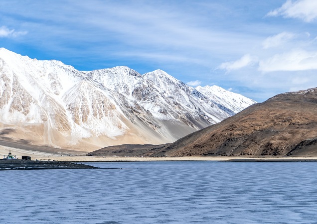 Snow-capped mountains and lake under a blue sky
