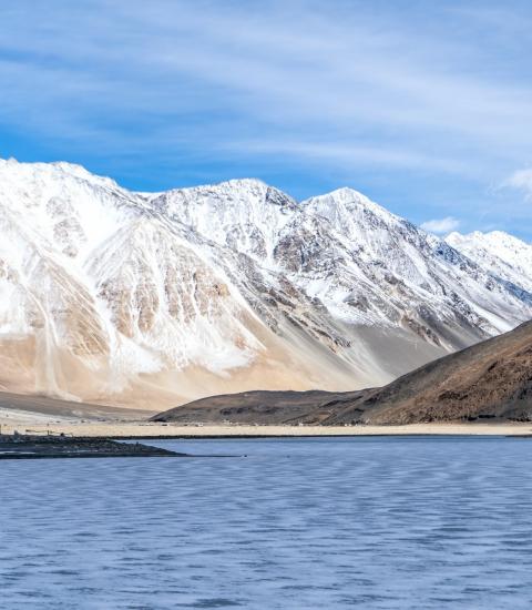 Snow capped mountains and lake under a blue sky