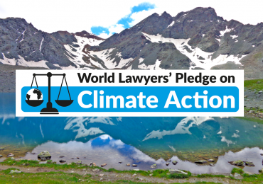 climate pledge logo on a background of mountains and lake