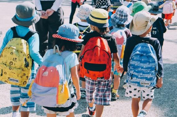 School children walking away with colorful backpacks